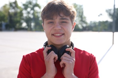 Photo of Portrait of teenage boy with headphones on city street