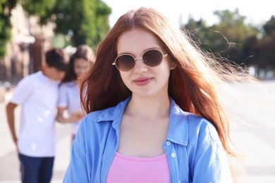 Photo of Portrait of teenage girl on city street, selective focus