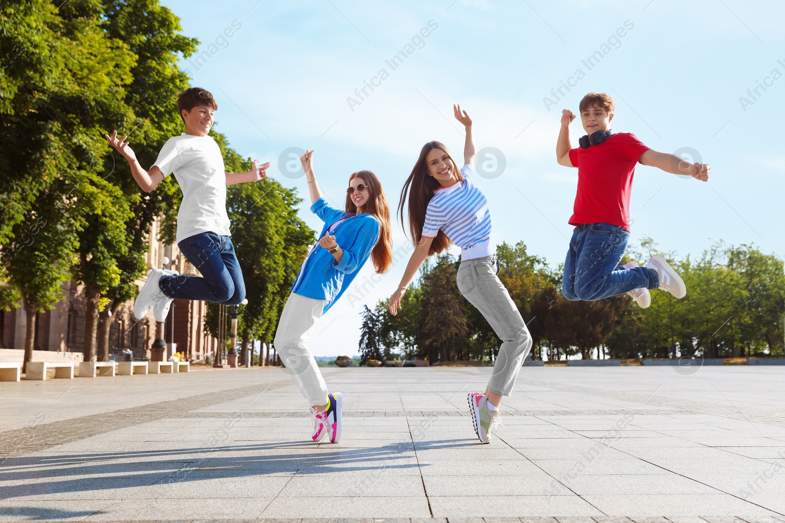 Group of teenagers having fun together on city street Photo of Group of teenagers having fun together on city street