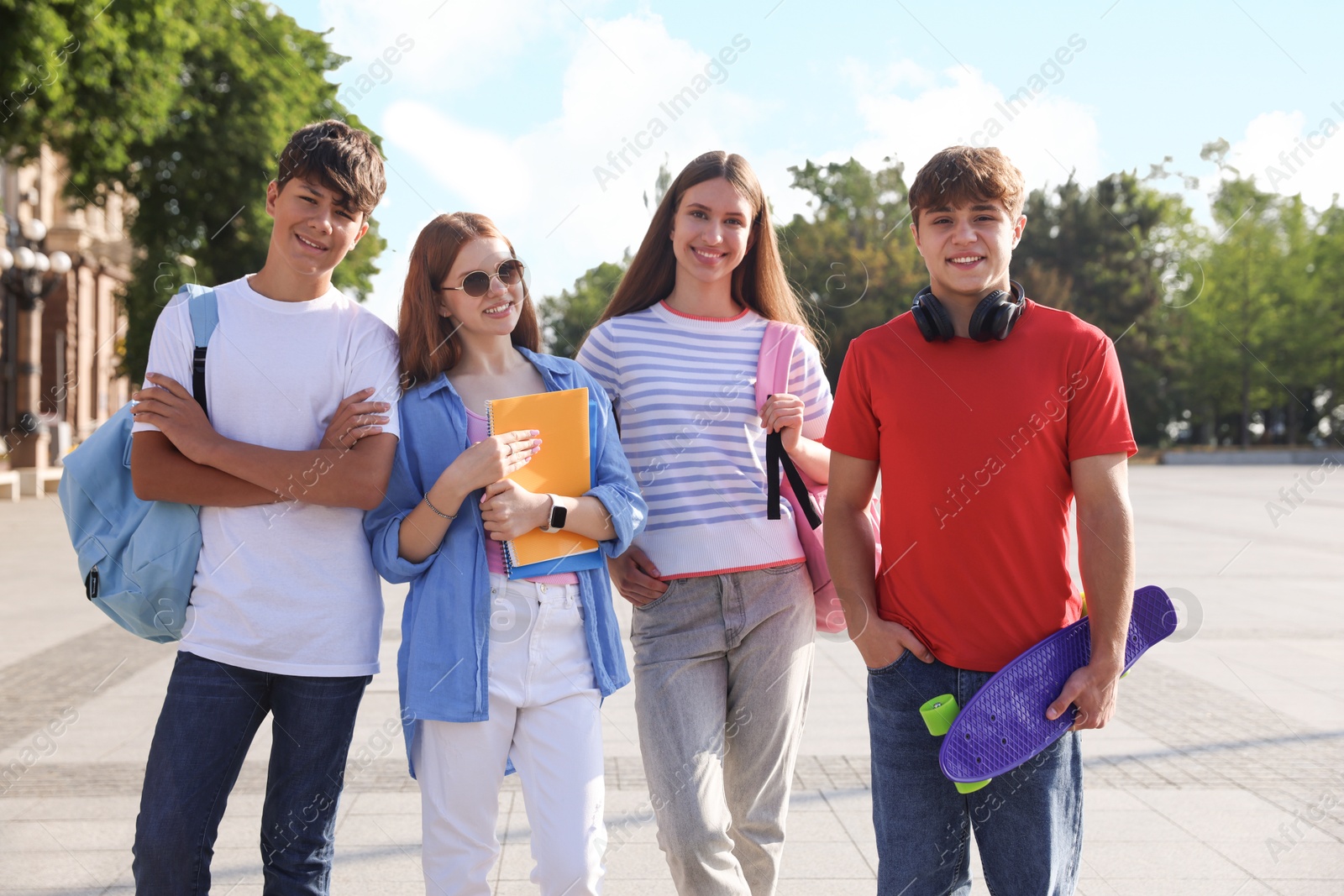 Group of teenagers walking together on city street Photo of Group of teenagers walking together on city street