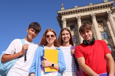 Photo of Group of teenagers walking together on city street, low angle view