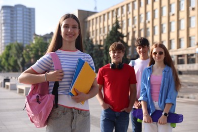 Photo of Group of teenagers walking together on city street, selective focus