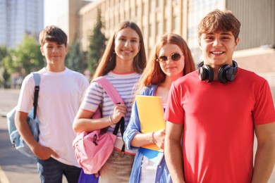 Photo of Group of teenagers walking together on city street, selective focus