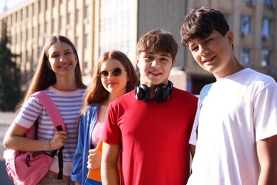 Photo of Group of teenagers walking together on city street, selective focus