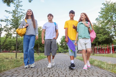 Photo of Group of teenagers spending time together outdoors, low angle view