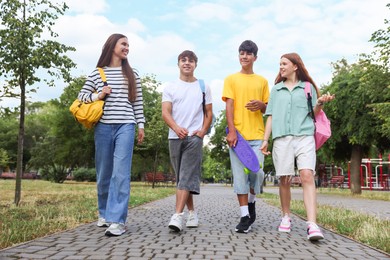 Photo of Group of teenagers spending time together outdoors, low angle view