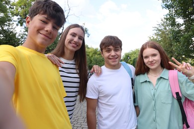 Photo of Group of teenagers taking selfie in park