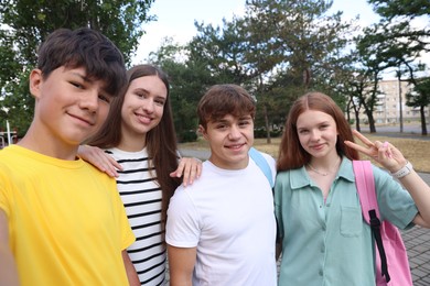 Photo of Group of teenagers taking selfie in park