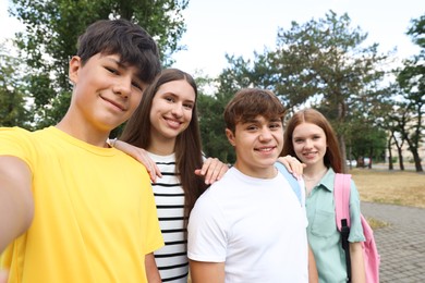 Photo of Group of teenagers taking selfie in park