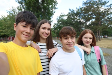 Photo of Group of teenagers taking selfie in park