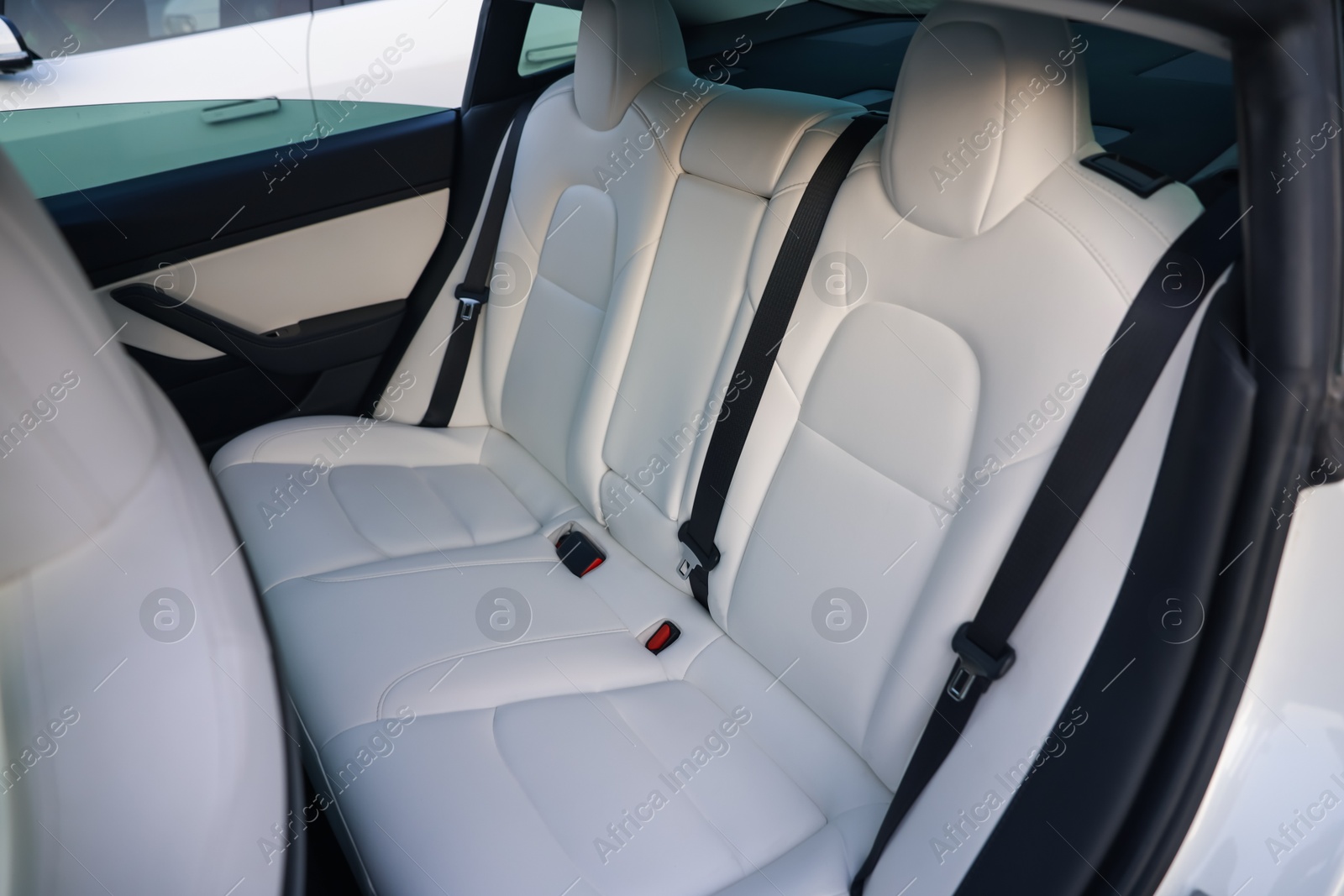 Photo of Modern car interior with seats and safety belts, view from outside