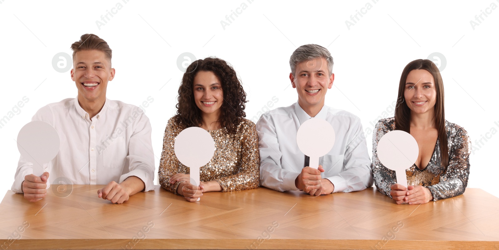 Panel of happy judges with blank score signs at table on white background Photo of Panel of happy judges with blank score signs at table on white background