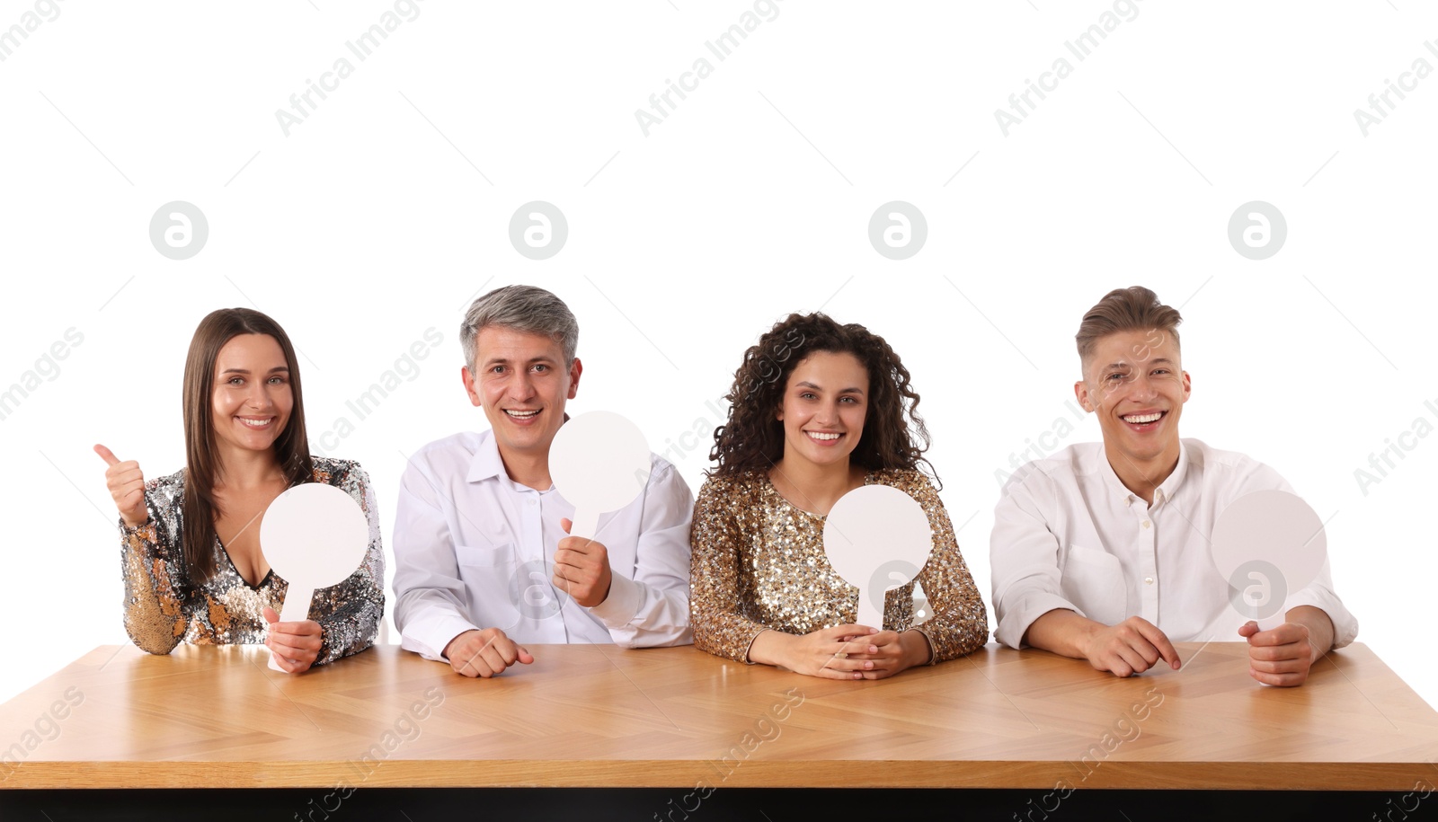 Panel of happy judges with blank score signs at table on white background Photo of Panel of happy judges with blank score signs at table on white background