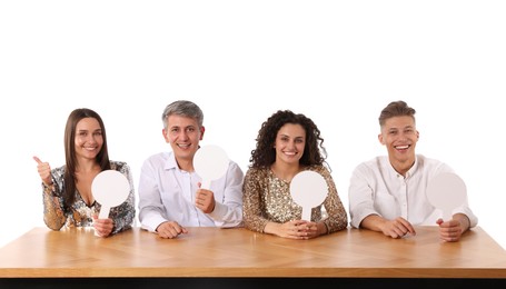 Photo of Panel of happy judges with blank score signs at table on white background