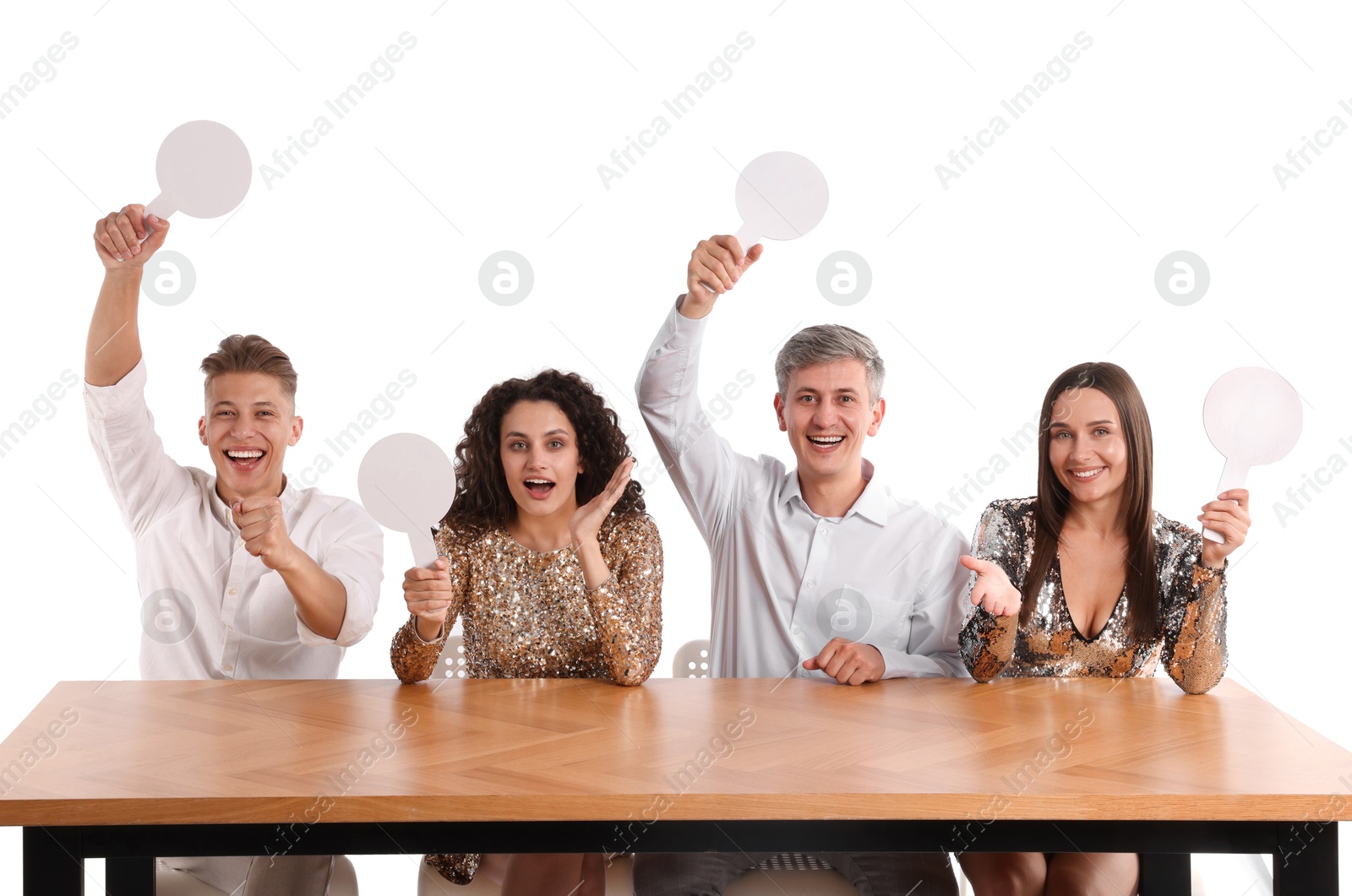 Panel of happy judges with blank score signs at table on white background Photo of Panel of happy judges with blank score signs at table on white background