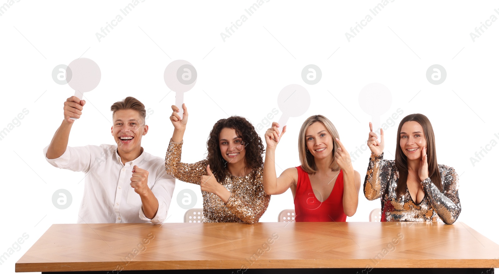 Panel of happy judges with blank score signs at table on white background Photo of Panel of happy judges with blank score signs at table on white background