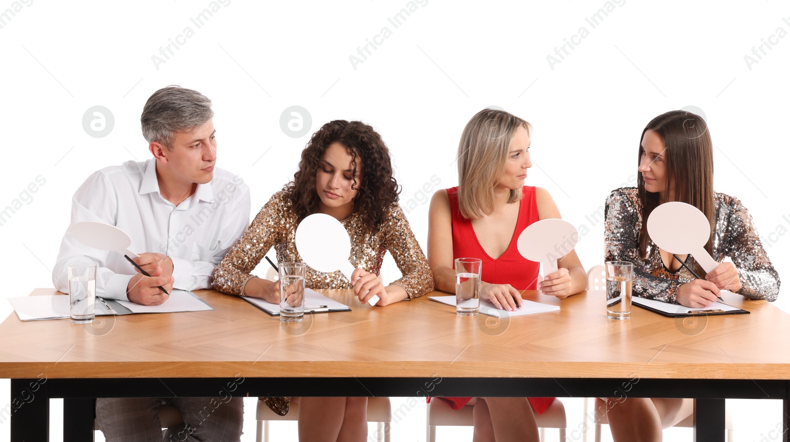 Panel of judges with blank score signs at table on white background Photo of Panel of judges with blank score signs at table on white background