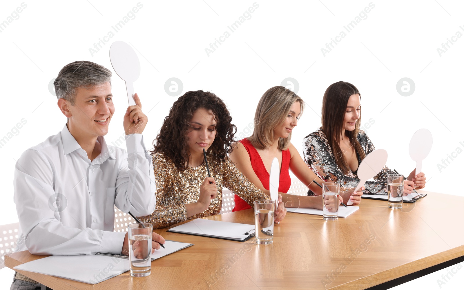 Panel of judges with blank score signs at table on white background Photo of Panel of judges with blank score signs at table on white background