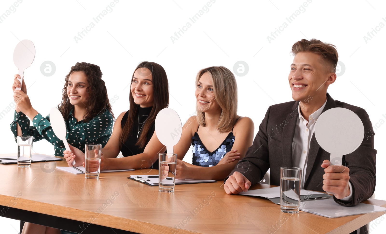 Panel of happy judges with blank score signs at table on white background Photo of Panel of happy judges with blank score signs at table on white background