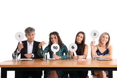 Photo of Panel of judges voting with score signs at table on white background