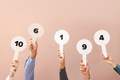 Photo of Panel of judges voting with score signs on beige background, closeup