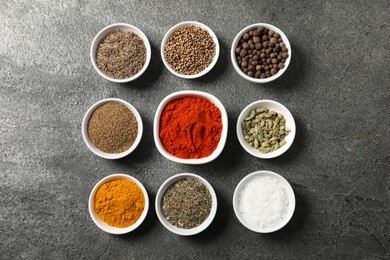 Photo of Different aromatic spices on grey table, flat lay