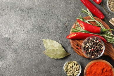 Photo of Different aromatic spices on grey table, flat lay. Space for text