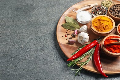 Photo of Different aromatic spices on grey table, closeup. Space for text