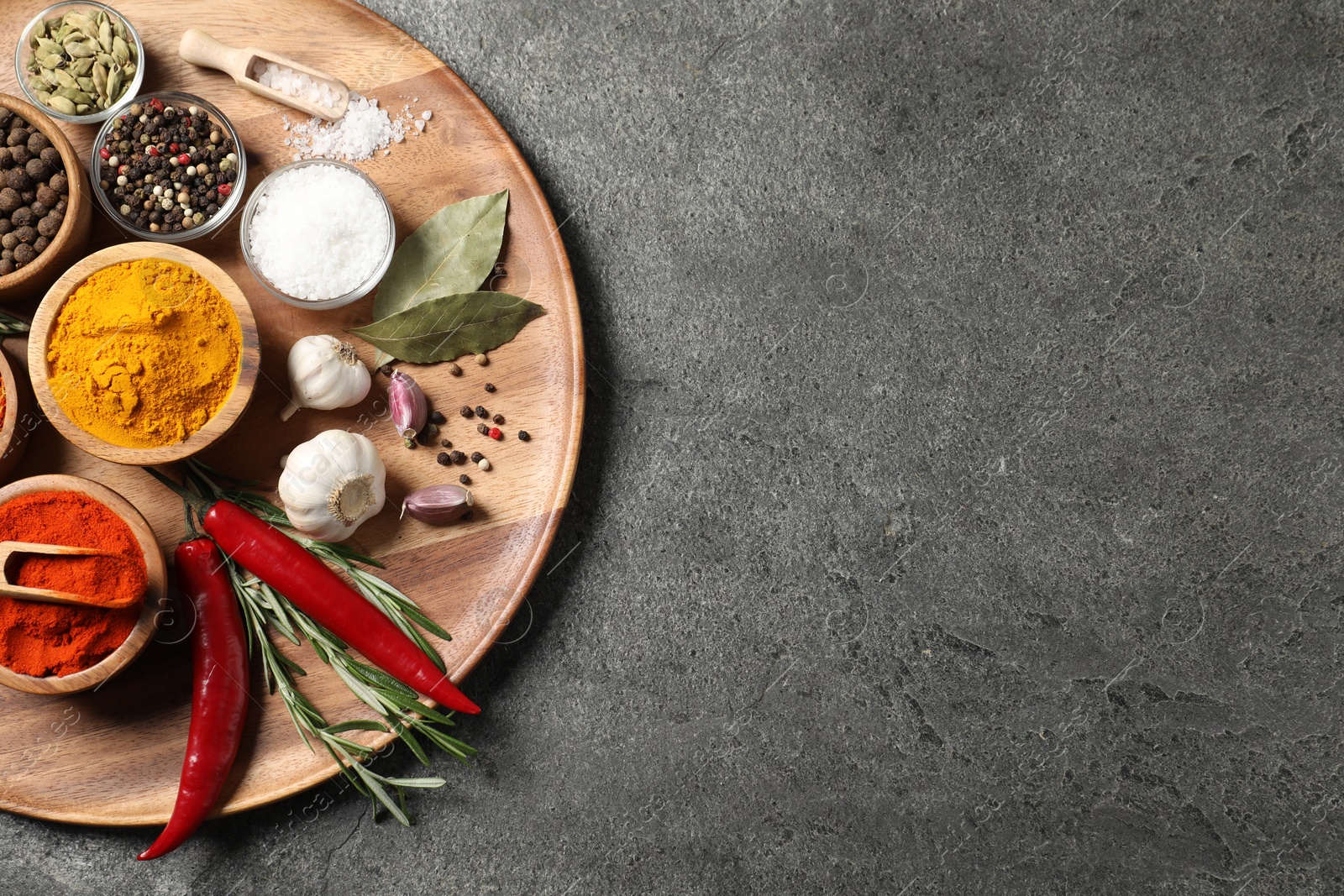 Different aromatic spices on grey table, top view. Space for text Photo of Different aromatic spices on grey table, top view. Space for text