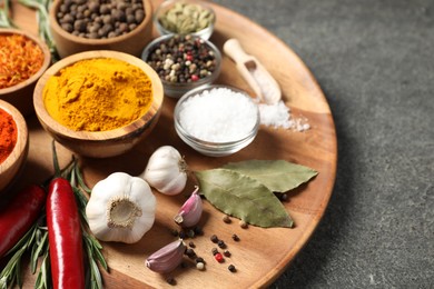 Photo of Different aromatic spices on grey table, closeup