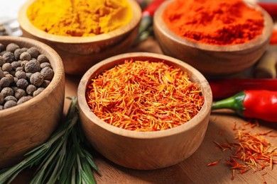 Photo of Different aromatic spices on wooden board, closeup