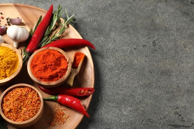Photo of Different aromatic spices on grey table, above view. Space for text