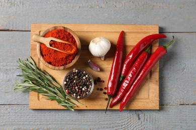Photo of Different aromatic spices on grey wooden table, top view