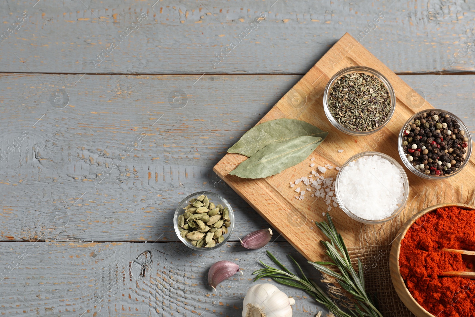 Different aromatic spices on grey wooden table, flat lay. Space for text Photo of Different aromatic spices on grey wooden table, flat lay. Space for text