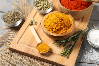 Photo of Different aromatic spices on grey wooden table, closeup