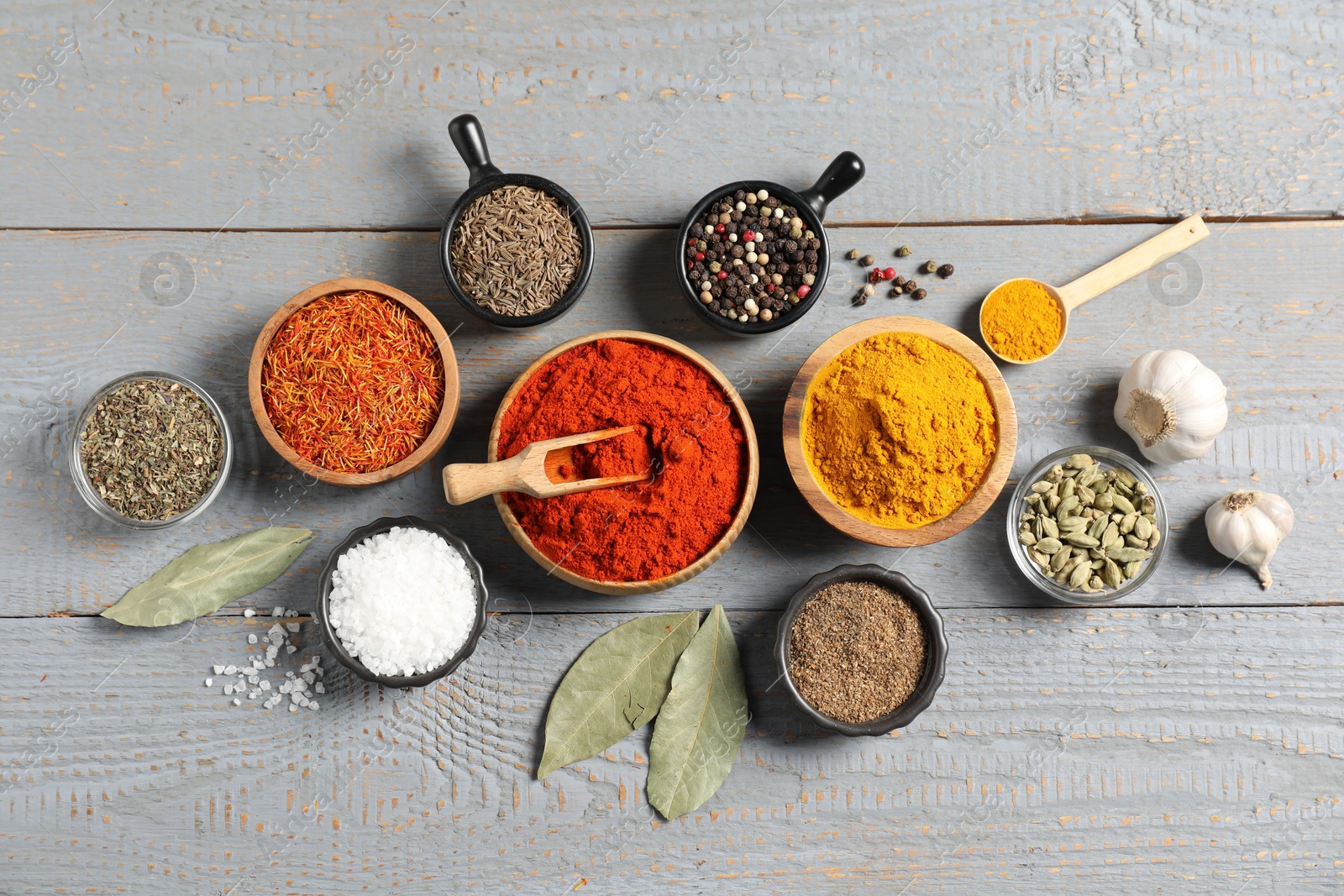 Different aromatic spices on grey wooden table, flat lay Photo of Different aromatic spices on grey wooden table, flat lay