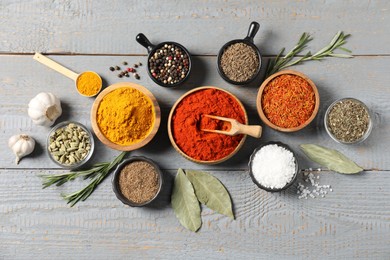 Photo of Different aromatic spices on grey wooden table, flat lay