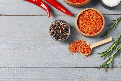 Photo of Different aromatic spices on grey wooden table, flat lay. Space for text