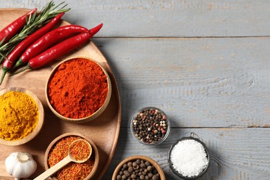 Photo of Different aromatic spices on grey wooden table, flat lay. Space for text