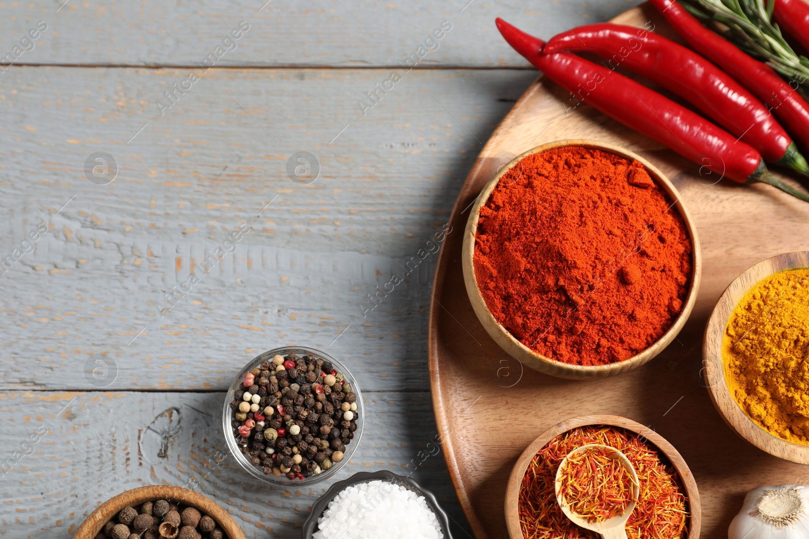 Different aromatic spices on grey wooden table, flat lay. Space for text Photo of Different aromatic spices on grey wooden table, flat lay. Space for text