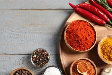 Photo of Different aromatic spices on grey wooden table, flat lay. Space for text