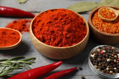 Photo of Different aromatic spices on grey wooden table, closeup