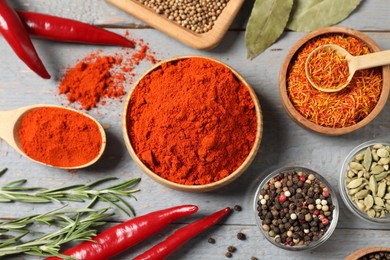 Photo of Different aromatic spices on grey wooden table, flat lay