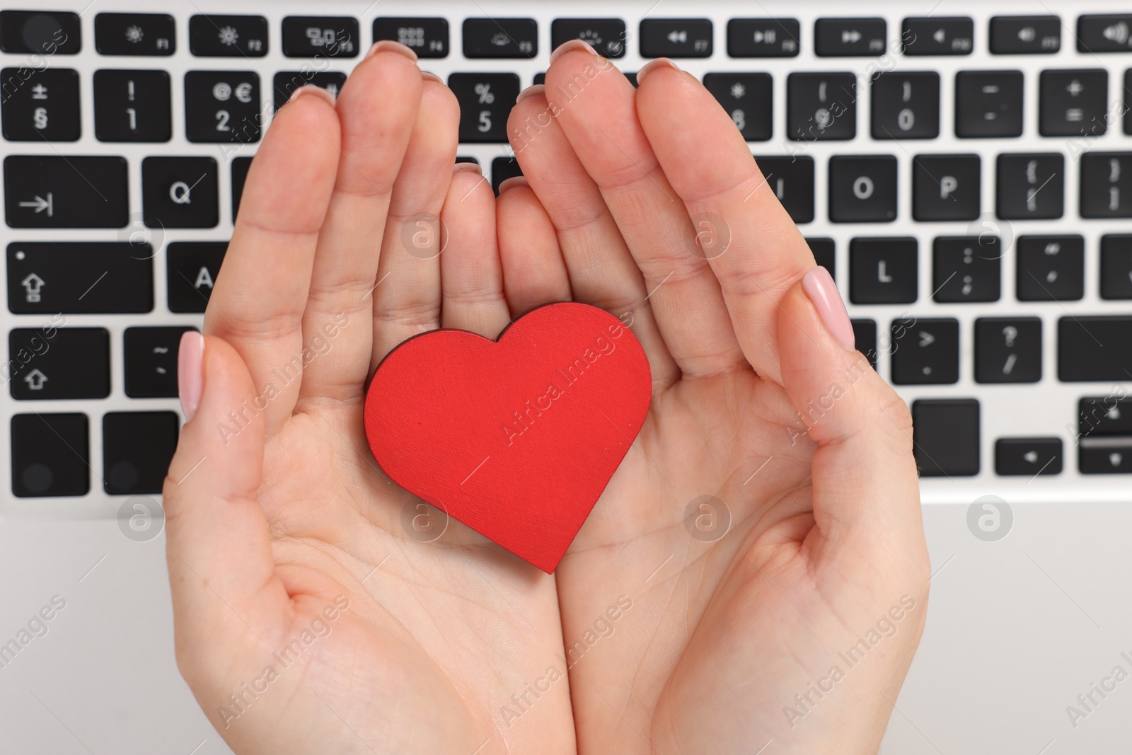 Online dating site. Woman with decorative heart over laptop, top view Photo of Online dating site. Woman with decorative heart over laptop, top view