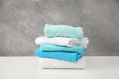 Photo of Stack of colorful towels on white table