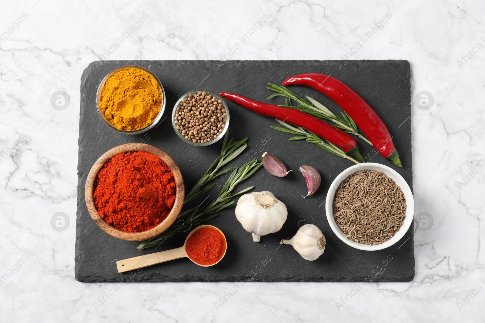 Photo of Different aromatic spices on white marble table, flat lay