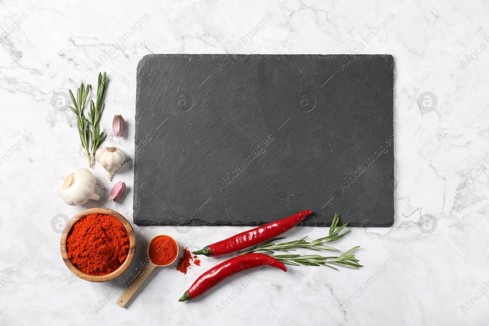 Different aromatic spices and slate board on white marble table, flat lay. Space for text Photo of Different aromatic spices and slate board on white marble table, flat lay. Space for text
