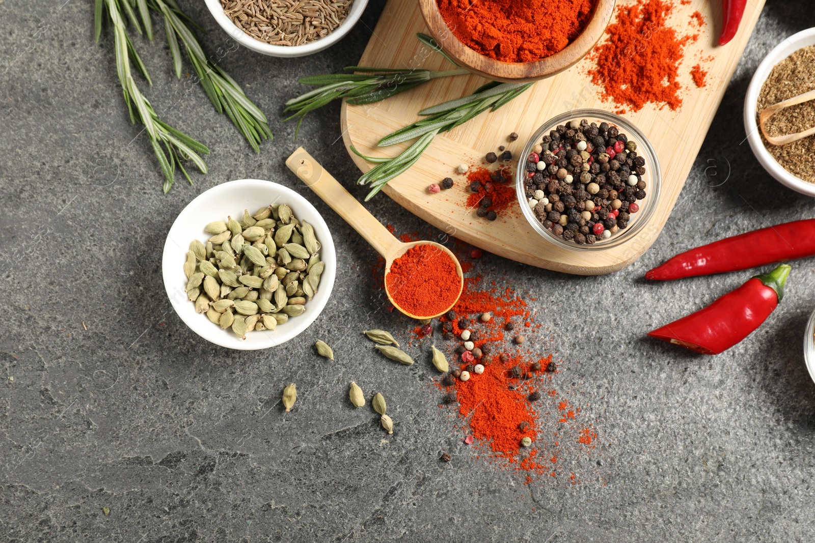 Photo of Different aromatic spices on grey table, flat lay