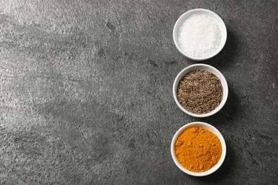 Photo of Different aromatic spices on grey table, flat lay. Space for text