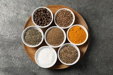 Photo of Different aromatic spices on grey table, top view